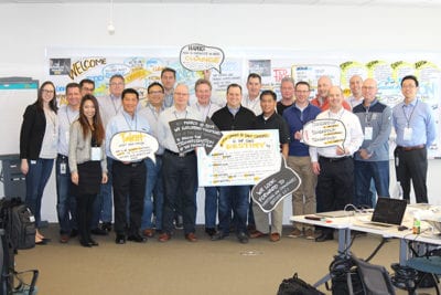 Corporate team after graphic facilitation session standing with their work from the day