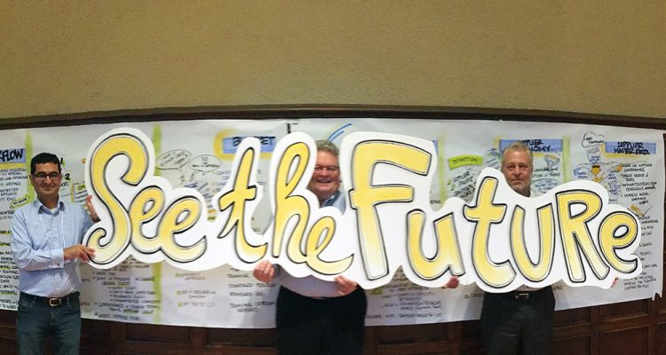 See the Future graphic held by three corporate team member after graphic facilitation session